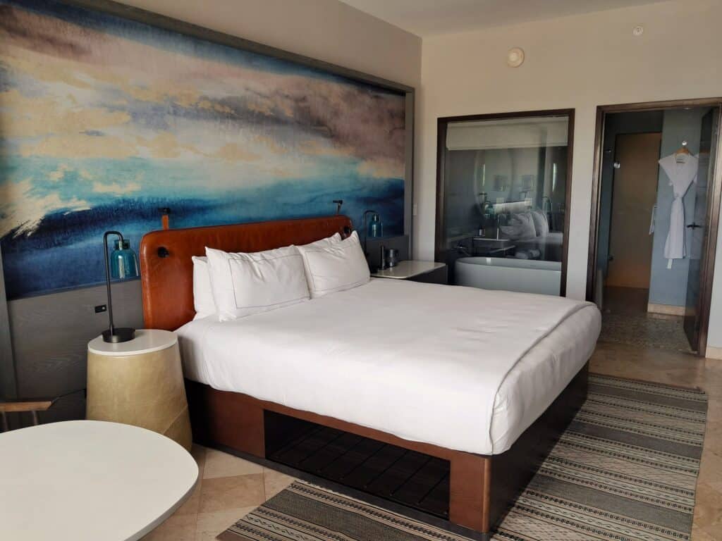 Studio room with king size bed and glass window to the bathroom.
