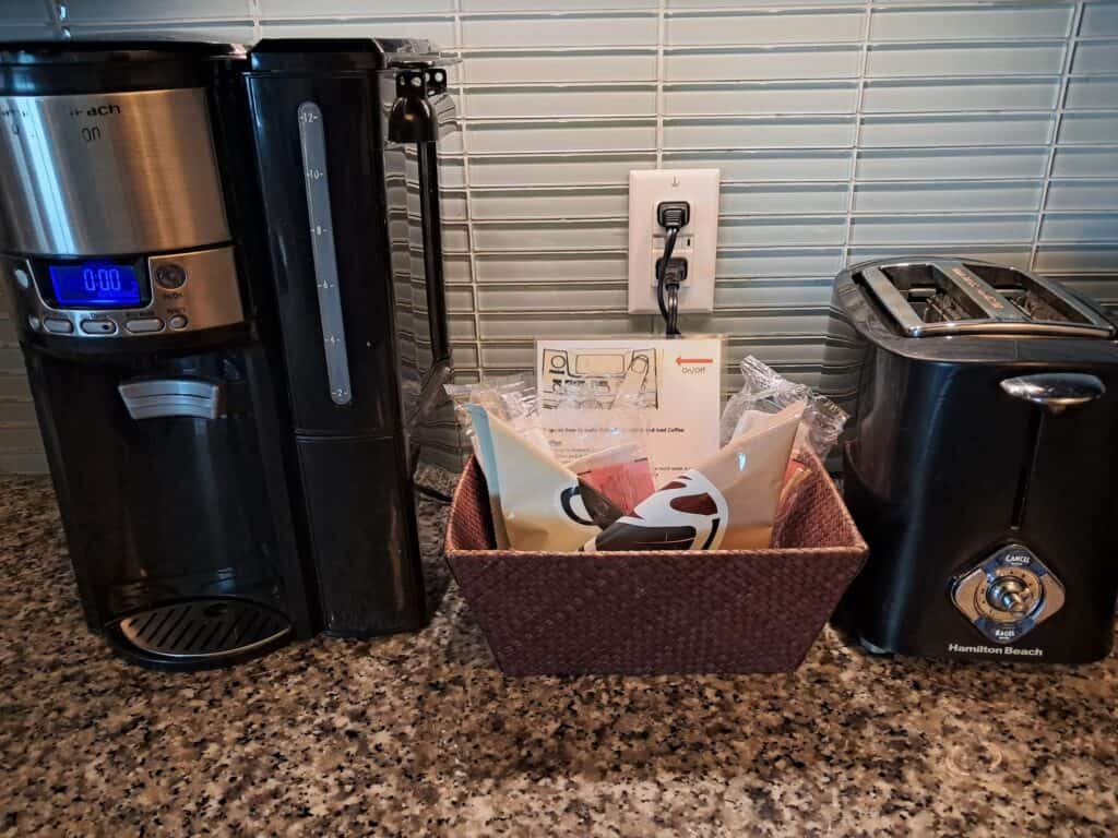 Drip coffee maker, basket with complimentary coffe packets, and toaster in review of the Hilton Ocean 22.