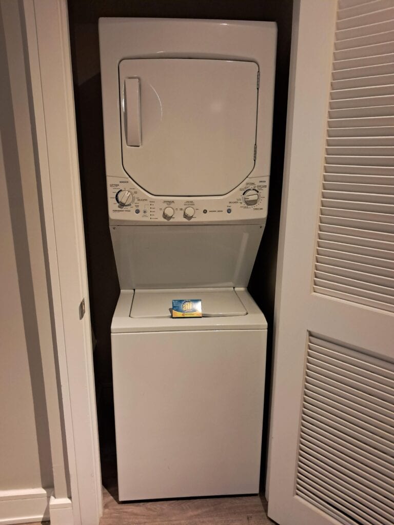 Stacking washer and dryer with a box of All detergent in the Hilton Ocean 22 unit.