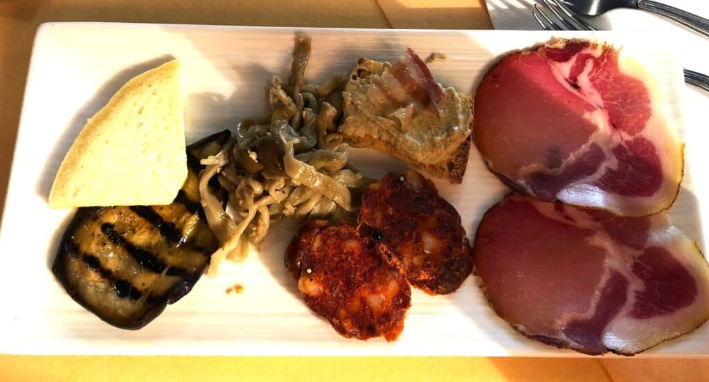 Plate of cheese, grilled vegetables, and meats at Le Puzzelle near Santa Severina.