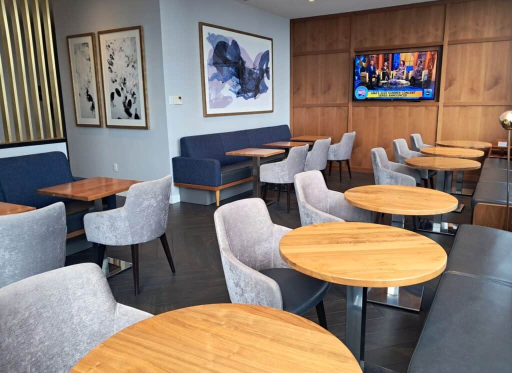 Owners lounge with tables, chairs, and a TV screen.