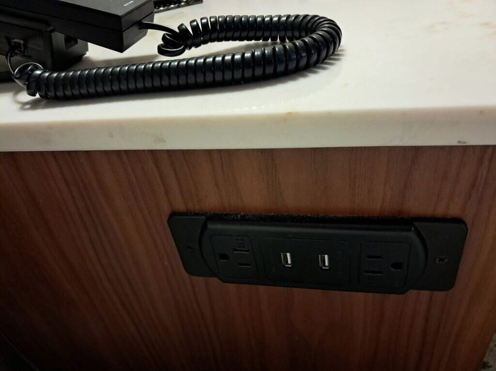 Plug outlets and USB slots for charging electronics next to the bed.