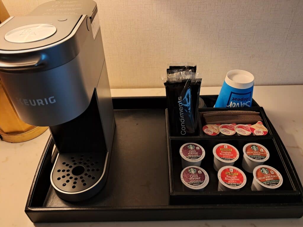 Keurig coffee maker with K Cups and condiments in the studio room.