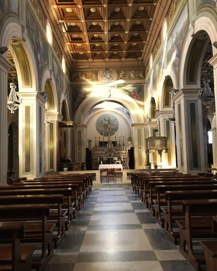 Interior of the Cathedral with an altar, arches and a wooden ceiling.