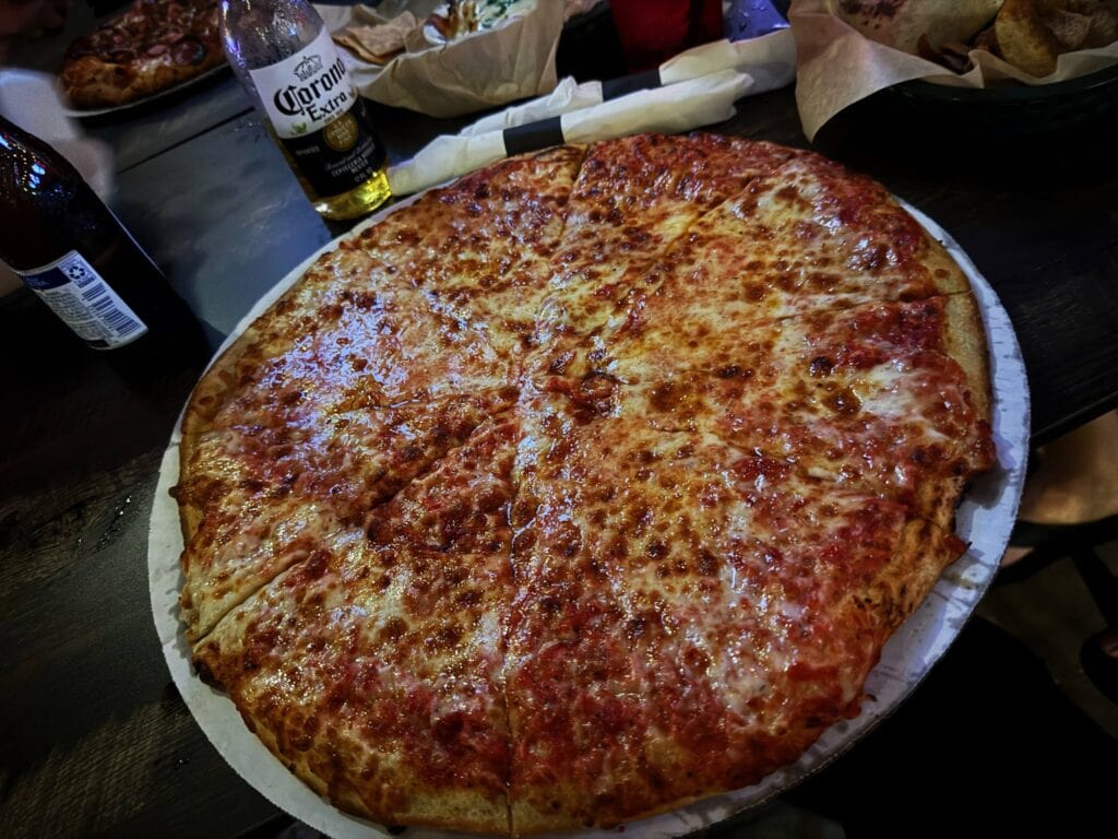 Large cheese pizza and Corona beer on the table at Sugarshack Bonita Springs.