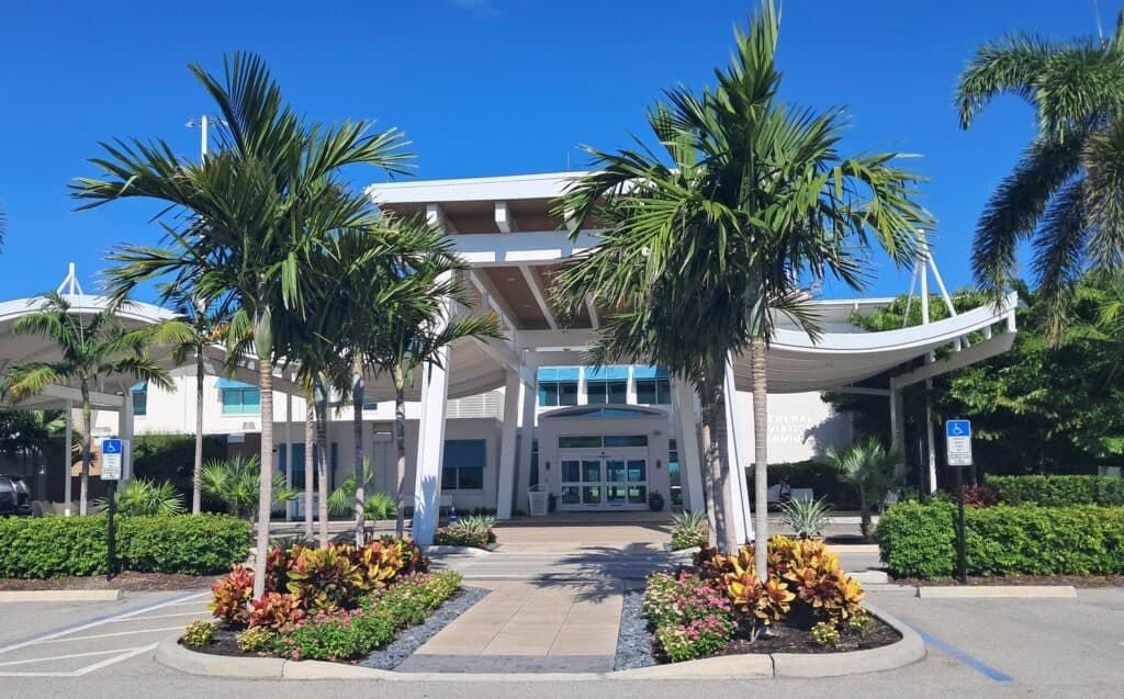 Front entrance the Genral Aviation Terminal for the Naples Airport tour with palm trees and sunshine.