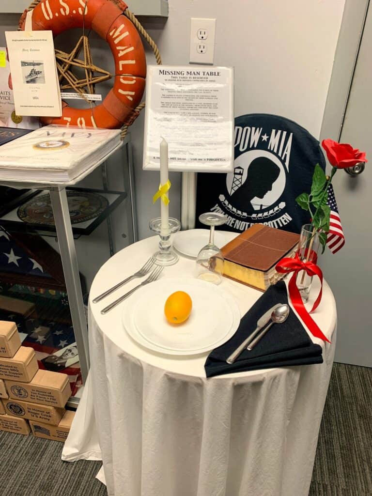 The Missing Man Table has symbolic items like dinnerware place setting, a Bible, red rose, a vase, black napkin and a lemon in honor the missing comrade in arms.