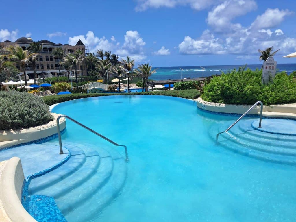 Main pool area at The Crane Resort with multiple levels with the Atlantic Ocean in the background.