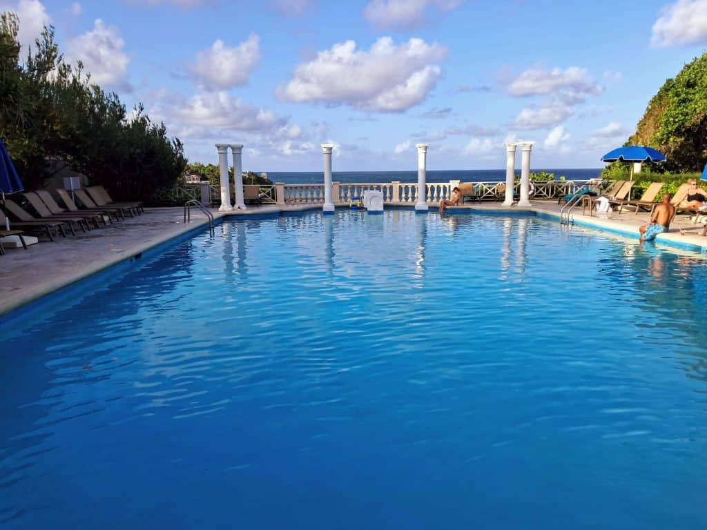 The historic pool with Doric Columns with the ocean in the background at The Crane Resort Barbados.