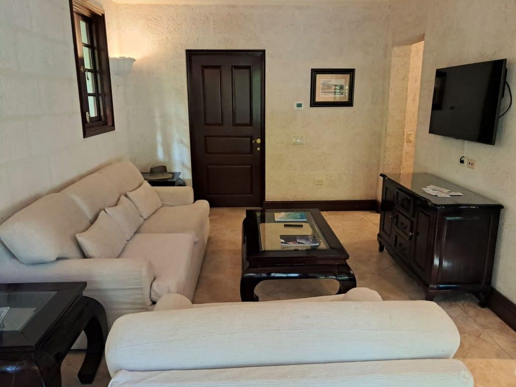 Living room with couch, large chair, TV hanging on the wall. coffee table, and credenza.