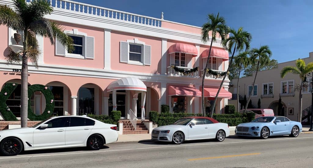 Pink buildings on 3rd Street South with expensive cars parked in front in Naples Florida.