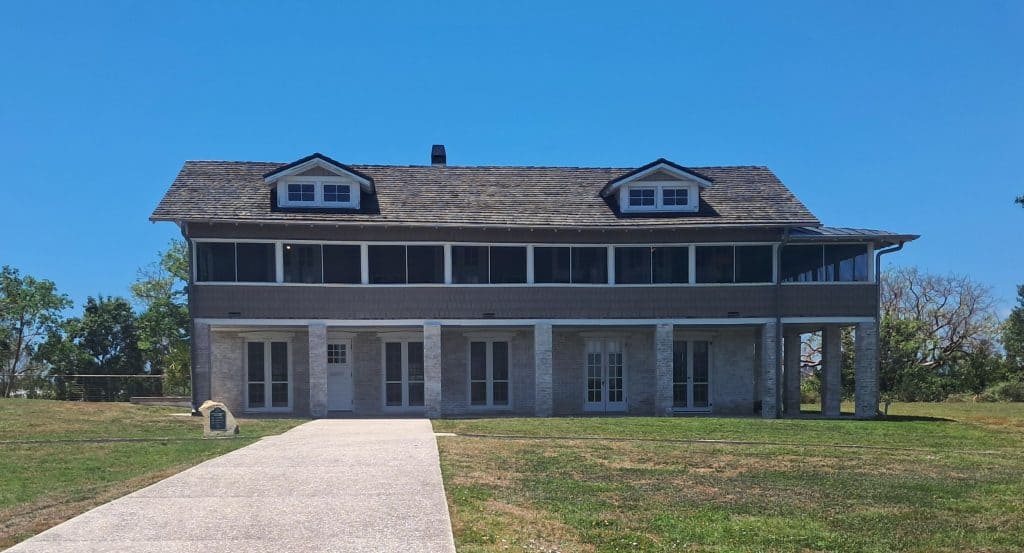 Two-story house with windows and balconies built on a mound of seashells by the Calusa natives in Fort Myers Beach.